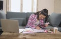Young attractive and happy hispanic woman checking bills bank papers expenses and monthly payments smiling at apartment living roo Royalty Free Stock Photo