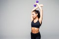 Young attractive woman in sport clothes with beautiful smile holding weight dumbbell doing fitness workout isolated on white backg Royalty Free Stock Photo