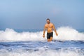 Young attractive and happy man with beard and swimming trunks at tropical paradise desert beach alone playful and cheerful in sea