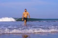 Young attractive and happy man with beard and swimming trunks at tropical paradise desert beach alone playful and cheerful in sea