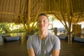 Young attractive and happy man doing yoga sitting in lotus position meditating relaxed in harmony at beautiful Asian bamboo hut Royalty Free Stock Photo