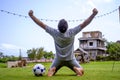 Young attractive and happy man playing football on his knees on grass field emulating professional soccer player gesture when cele Royalty Free Stock Photo