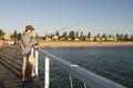 Young attractive and happy man in shirt and hat fishing at beach Royalty Free Stock Photo