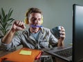 Young attractive and happy man with yellow headphones sitting at home office desk working with laptop computer having fun listenin Royalty Free Stock Photo