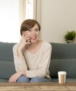 Young attractive and happy red hair woman sitting at home sofa c Royalty Free Stock Photo