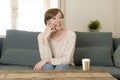 Young attractive and happy red hair woman sitting at home sofa c Royalty Free Stock Photo