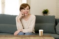 Young attractive and happy red hair woman sitting at home sofa c Royalty Free Stock Photo