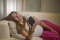 Young attractive happy and relaxed student Asian woman enjoying homey lying at living room sofa couch using internet social media Royalty Free Stock Photo