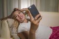 Young attractive happy and relaxed student Asian woman enjoying homey lying at living room sofa couch using internet social media Royalty Free Stock Photo