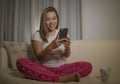 Young attractive happy and relaxed student girl enjoying homey sitting at living room sofa couch using internet social media or Royalty Free Stock Photo