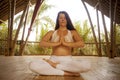 Young attractive and happy relaxed woman sitting in lotus yoga position doing meditation and concentration outdoors at wooden hut Royalty Free Stock Photo