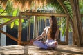 Young attractive and happy relaxed woman sitting in lotus yoga position doing meditation and concentration outdoors at wooden hut Royalty Free Stock Photo