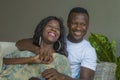 Young attractive and happy romantic African American couple in love lying playful cuddling at living room couch playing together Royalty Free Stock Photo