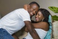 Young attractive and happy romantic afro American couple in love lying playful cuddling at living room couch playing together Royalty Free Stock Photo