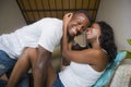Young attractive and happy romantic afro American couple in love lying playful cuddling at living room couch playing together Royalty Free Stock Photo