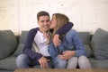 Young attractive happy and romantic couple boyfriend and girlfriend cuddle tender at home couch smiling playful in beautiful teena Royalty Free Stock Photo