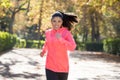 Attractive and happy runner woman in Autumn sportswear running a Royalty Free Stock Photo