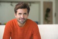 Young attractive and happy 30s man smiling relaxed and comfortable sitting at living room sofa couch in his modern apartment cheer