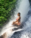 Young attractive and happy 30s woman with fit body practicing yoga wet under tropical paradise waterfall stream in meditation and Royalty Free Stock Photo