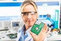 Young female electronic engineer holding HDD in hand