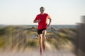 Young attractive and happy sport runner man with fit and strong healthy body training on off road track in Summer running workout Royalty Free Stock Photo