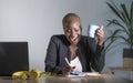 Young attractive and happy successful black afro american woman in business jacket working cheerful at office laptop taking notes Royalty Free Stock Photo