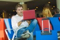 Young attractive and relaxed traveler man with luggage working with laptop computer waiting for flight at airport departure lounge Royalty Free Stock Photo