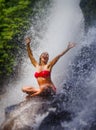 Young attractive and happy woman with fit body practicing yoga wet under tropical paradise waterfall stream screaming excited with Royalty Free Stock Photo