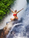 Young attractive and happy woman with fit body practicing yoga wet under tropical paradise waterfall stream screaming excited with Royalty Free Stock Photo