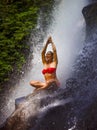 Young attractive and happy woman with fit body practicing yoga wet under tropical paradise waterfall stream screaming excited with Royalty Free Stock Photo