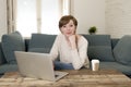 Young attractive and happy woman at home sofa couch doing some laptop computer work smiling relaxed in entrepreneur lifestyle Royalty Free Stock Photo