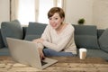 Young attractive and happy woman at home sofa couch doing some laptop computer work smiling relaxed in entrepreneur lifestyle Royalty Free Stock Photo