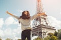 Young attractive happy woman jumping for joy against Eiffel Tower in Paris, France Royalty Free Stock Photo