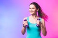 Portrait of young attractive happy woman in sport clothes with beautiful smile holding weight dumbbell doing fitness workout Royalty Free Stock Photo