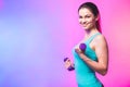 Portrait of young attractive happy woman in sport clothes with beautiful smile holding weight dumbbell doing fitness workout Royalty Free Stock Photo