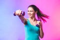 Portrait of young attractive happy woman in sport clothes with beautiful smile holding weight dumbbell doing fitness workout Royalty Free Stock Photo