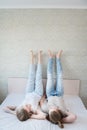 Young attractive heterosexual couple man and woman lie on the bed in the bedroom dressed in casual clothes. Weekend rest