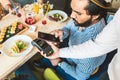 Young attractive Hindu man paying in cafe with contactless smartphone payment Royalty Free Stock Photo