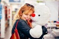 Young attractive hipster female smiling and hugging a big white teddy bear at the shop. Concept of valentine`s day Royalty Free Stock Photo