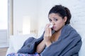 Young attractive hispanic woman lying sick at home couch in cold and flu in gripe disease symptom