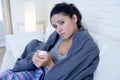 Young attractive hispanic woman lying sick at home couch in cold and flu in gripe disease symptom