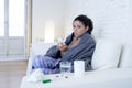 Young attractive hispanic woman lying sick at home couch in cold and flu in gripe disease symptom