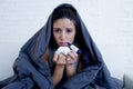 Young attractive hispanic woman lying sick at home couch in cold and flu in gripe disease symptom