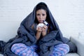 Young attractive hispanic woman lying sick at home couch in cold and flu in gripe disease symptom