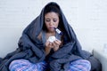 Young attractive hispanic woman lying sick at home couch in cold and flu in gripe disease symptom