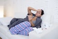 Young attractive hispanic woman lying sick at home couch in cold and flu in gripe disease symptom