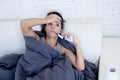 Young attractive hispanic woman lying sick at home couch in cold and flu in gripe disease symptom