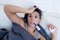 Young attractive hispanic woman lying sick at home couch in cold and flu in gripe disease symptom