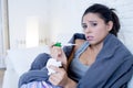 Young attractive hispanic woman lying sick at home couch in cold and flu in gripe disease symptom
