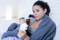 Young attractive hispanic woman lying sick at home couch in cold and flu in gripe disease symptom